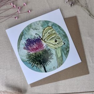 A printed card featuring an original hand-painted embroidered Brimstone Butterfly artwork resting on a thistle.