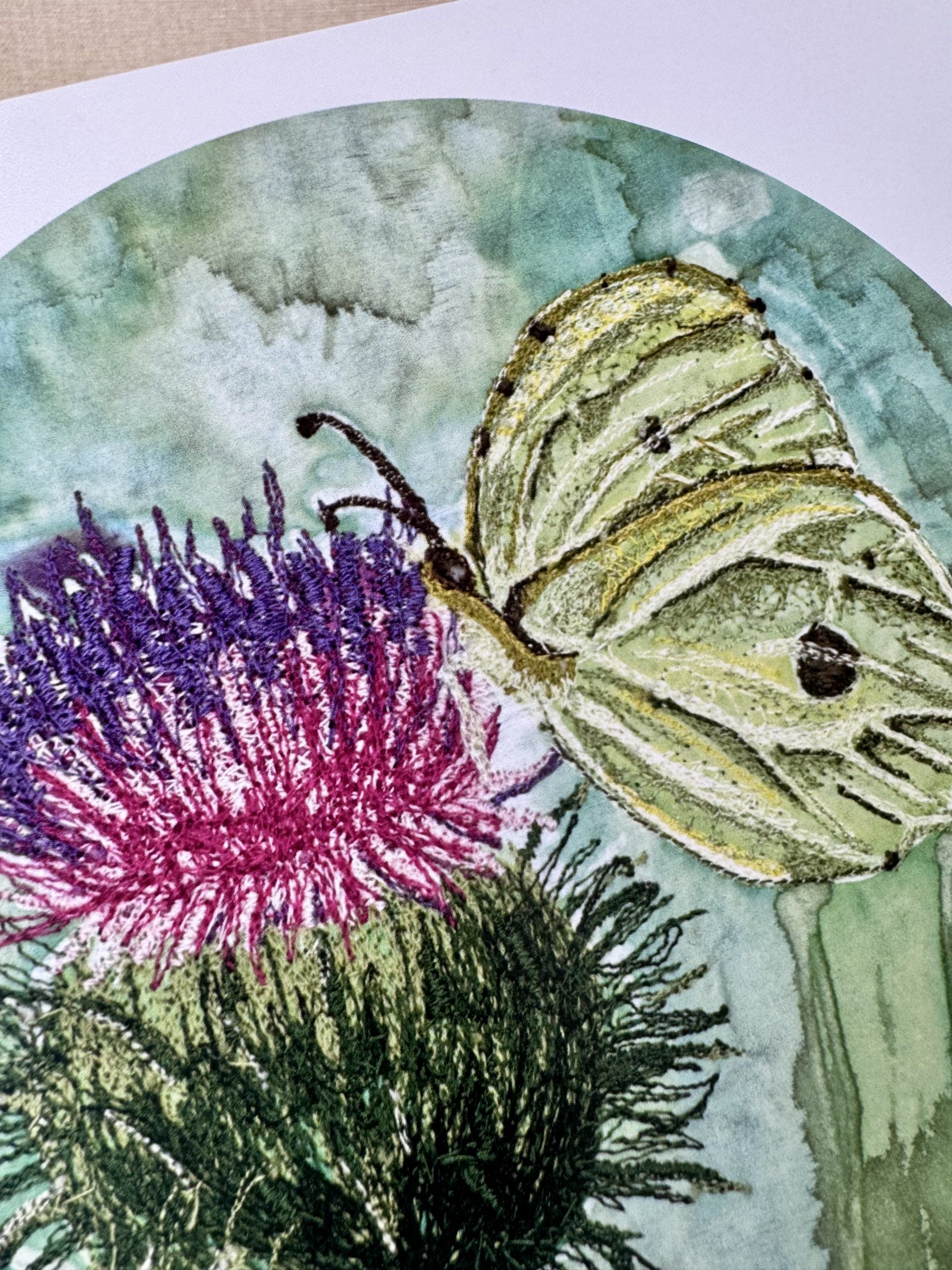 Brimstone butterfly resting on a purple thistle in a hand-painted embroidered artwork - zoomed in showing detail.