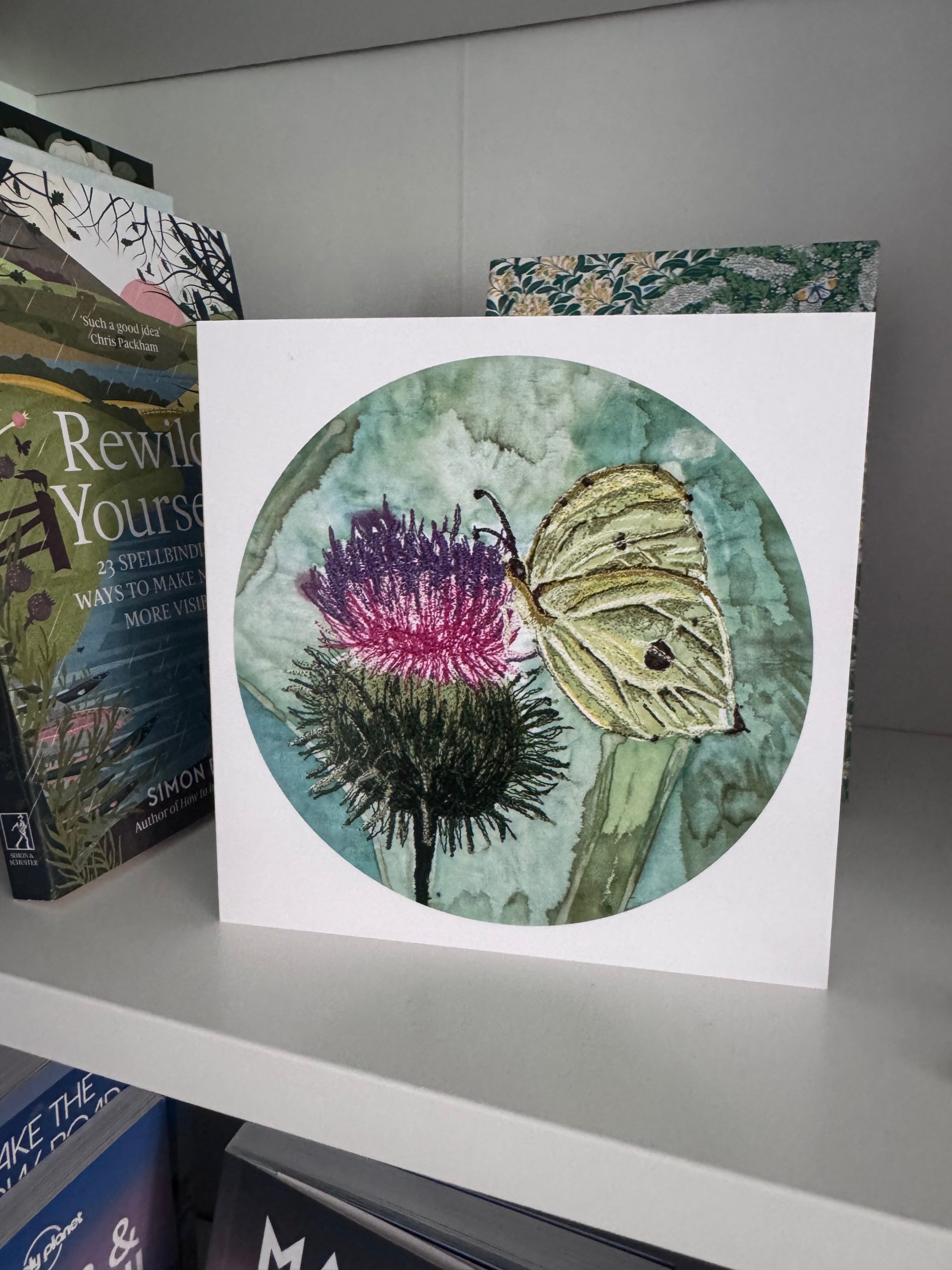 Brimstone butterfly resting on a purple thistle in a printed greetings card from an original hand-painted embroidered artwork.