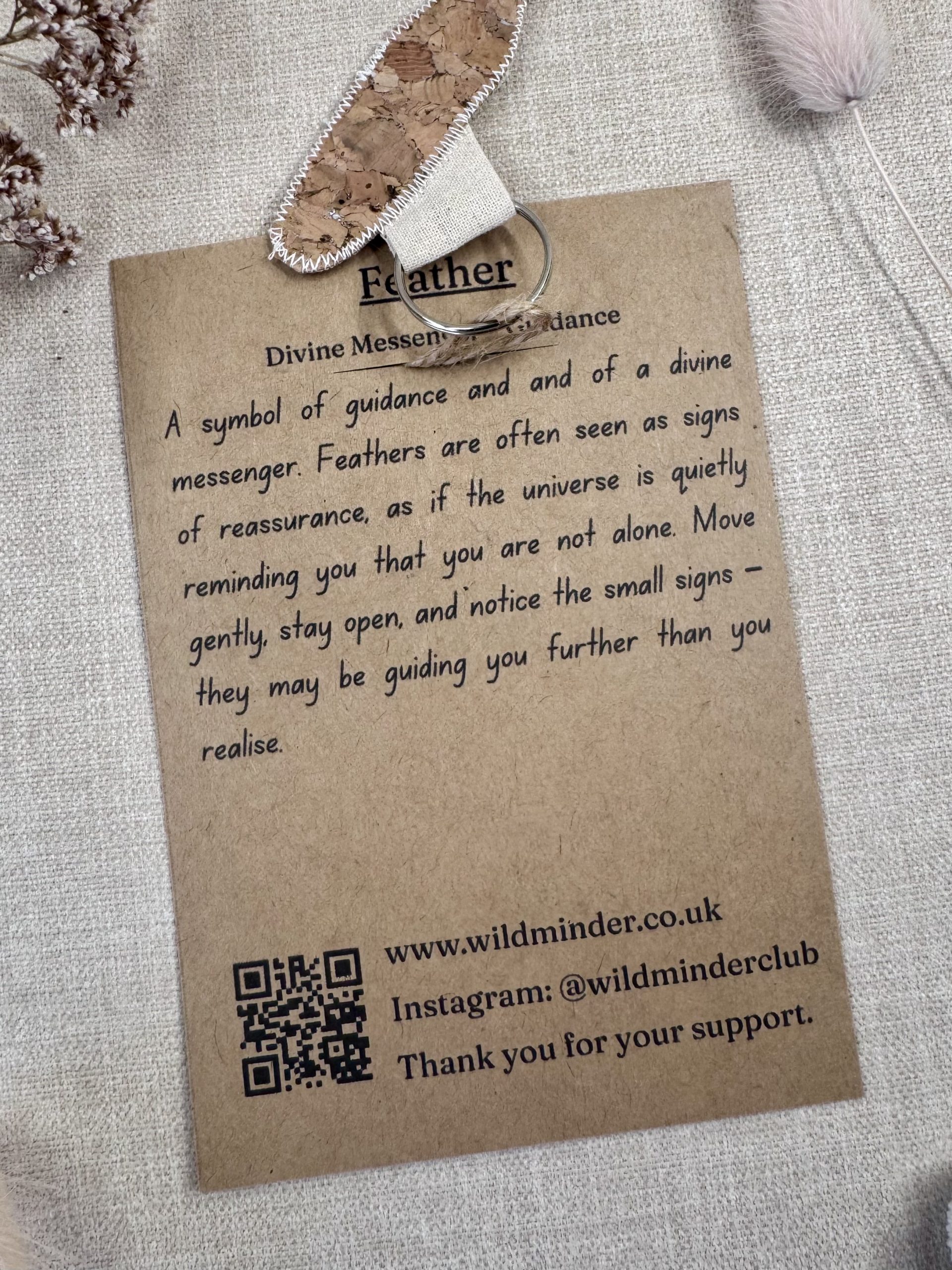 A photo of Feather Talisman Key Ring Backing card text